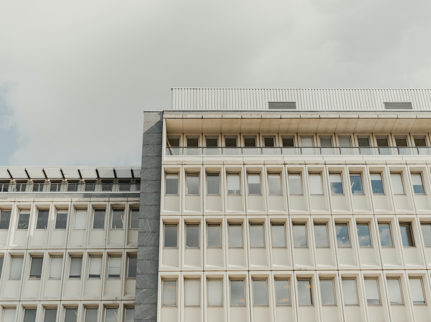 Modern office buildings featuring beige window frames and stone siding.