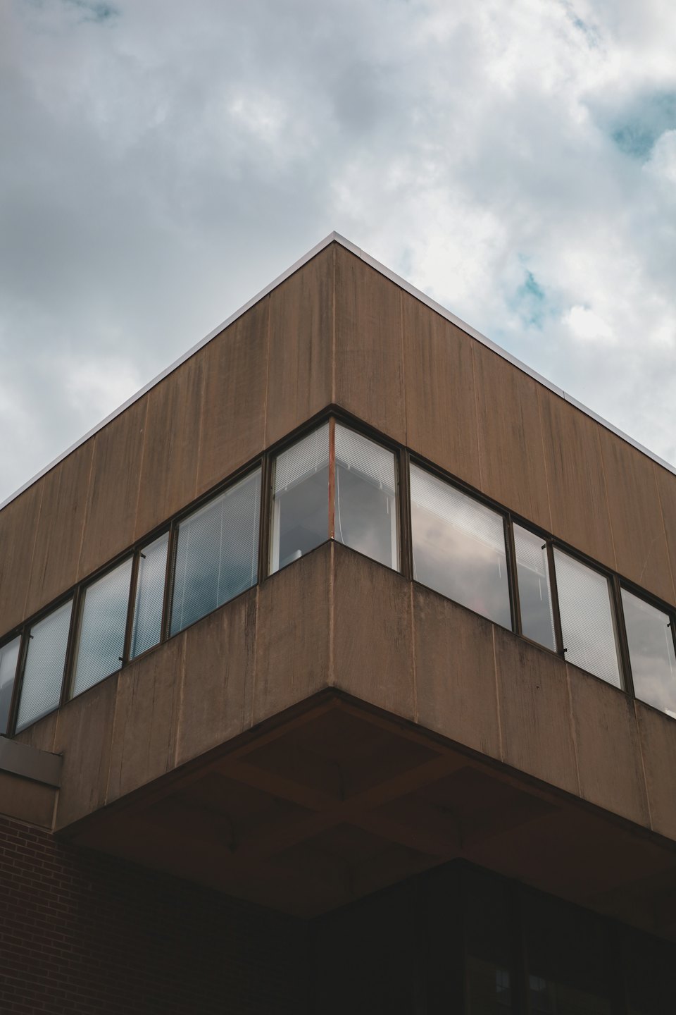 Brown concrete brutalist building with sharp geometric lines and windows.