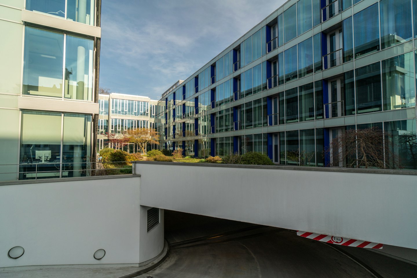 Modern office buildings with glass facades surround a courtyard garden.